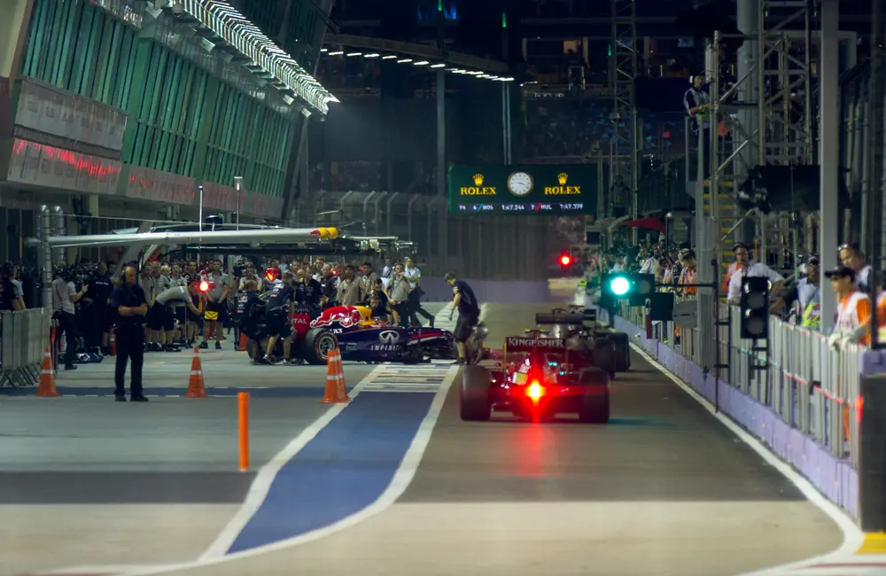 Formula 1 cars and team crews in the Singapore Grand Prix pit lane